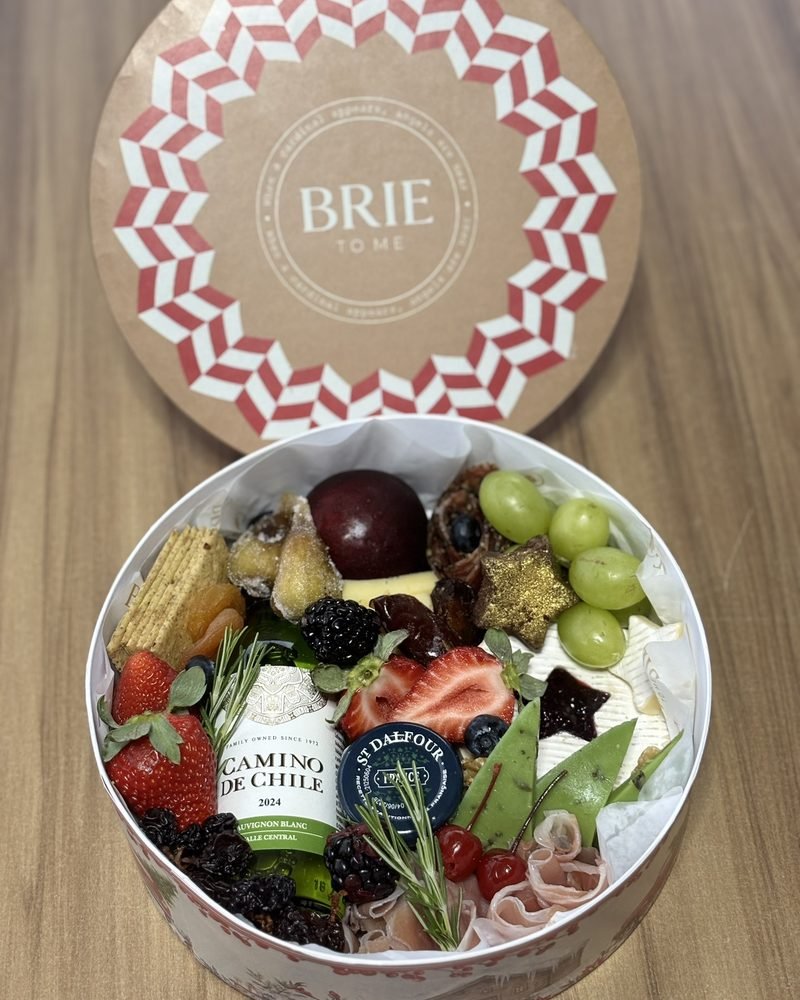 Caixa redonda Brie To Me com vinho, queijos, frutas e frios