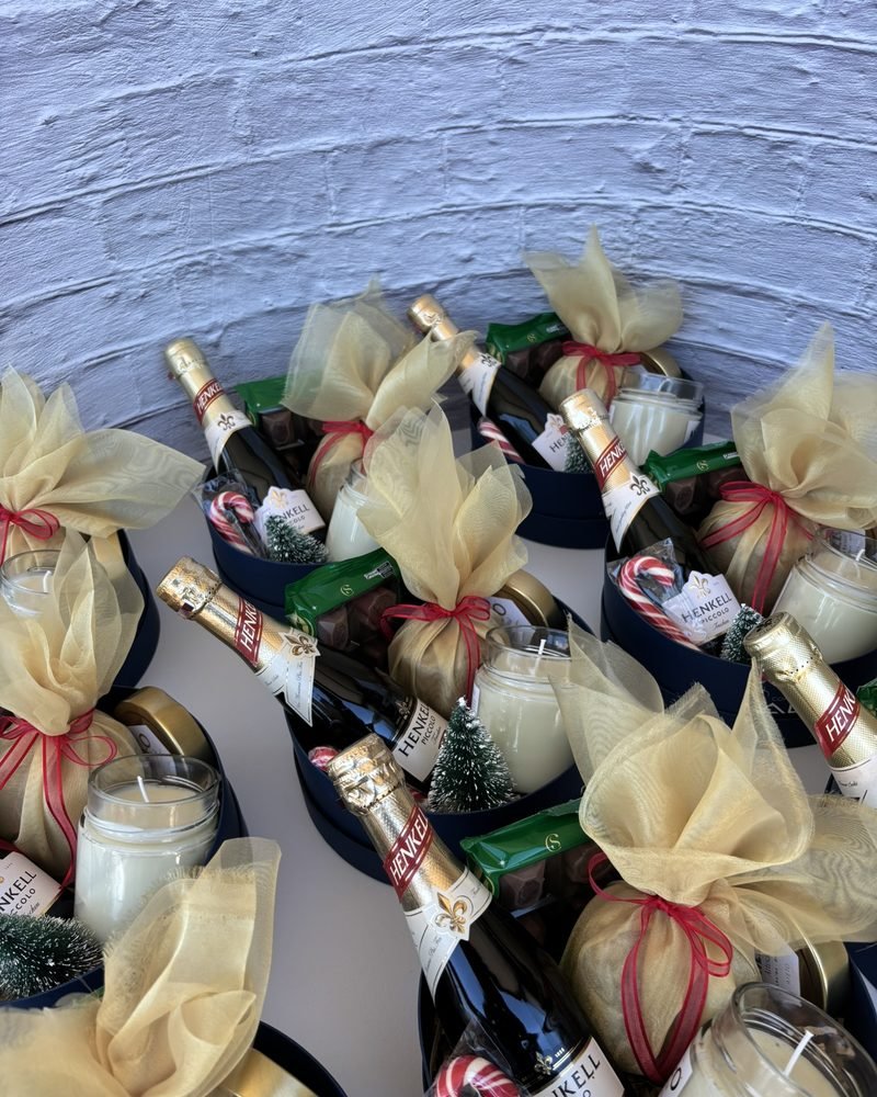 Presentes da Construtora Alcance com espumante, vela aromática, chocolates e panetone