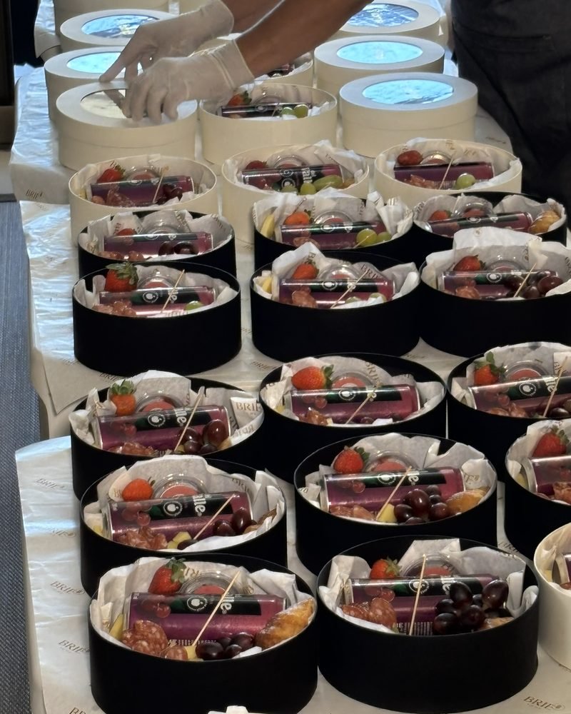 Dezenas de caixas com frutas e frios sendo montadas para um pedido corporativo